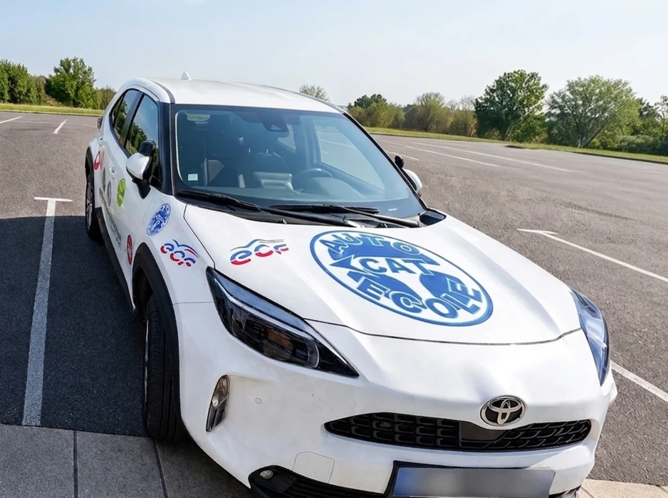 Véhicules d'auto-école garés en extérieur, signalés par des panneaux lumineux rouges "AUTO-ÉCOLE"