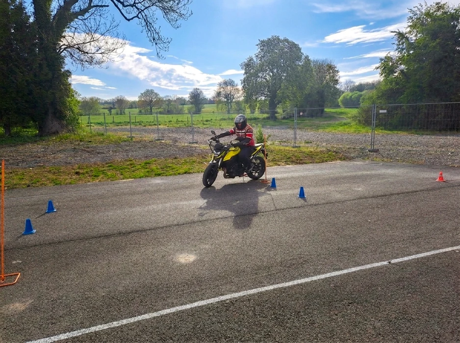 Piste d'entraînement extérieure balisée avec des cônes de signalisation bleus et orange, des jalons verticaux oranges sur socles et des cônes rouges et blancs